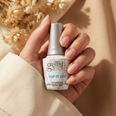 Mano sosteniendo top coat Gelish Top It Off Sealer Gel
