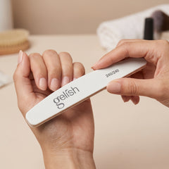 Manos sosteniendo la lima delgada de madera Gelish 240/240