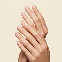 Mano con uñas naturales junto a las toallitas Gelish Wipe It Off