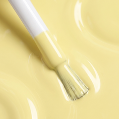 Primer plano del pincel con esmalte tradicional Morgan Taylor Let Down Your Hair, color Amarillos acabado Cream, textura del color