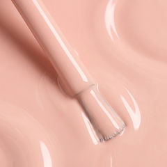 Primer plano del pincel con esmalte tradicional Morgan Taylor Barely Buff, color Nudes acabado Cream, textura del color