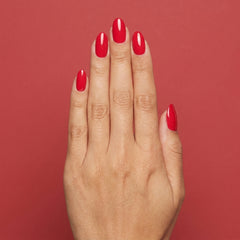 Mano con las uñas pintadas con esmalte tradicional Morgan Taylor Fire Cracker, color Rojos acabado Cream