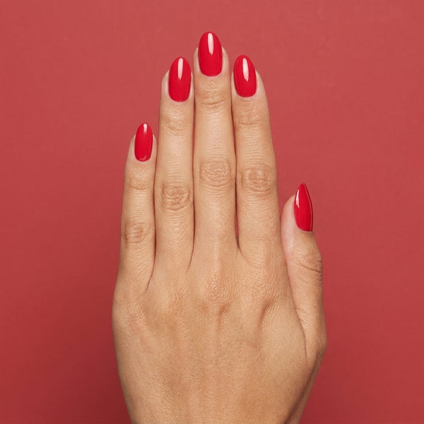 Mano con las uñas pintadas con esmalte tradicional Morgan Taylor Fire Cracker, color Rojos acabado Cream