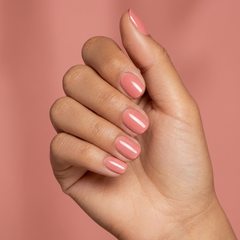 Mano con las uñas pintadas con esmalte tradicional Morgan Taylor Simple Sheer, color Nudes acabado Cream