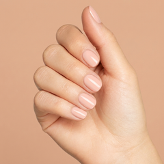 Mano con las uñas pintadas con esmalte tradicional Morgan Taylor Forever Beauty, color Nudes acabado Cream