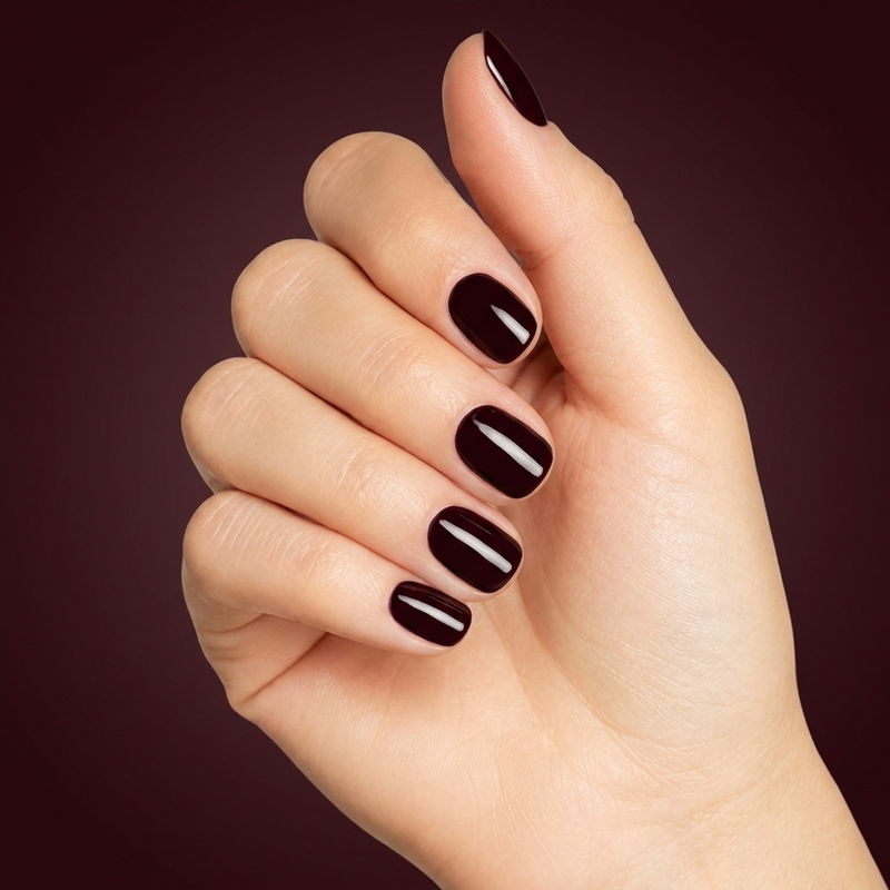 Mano con las uñas pintadas con esmalte tradicional Morgan Taylor Bella's Vampire, color Negros acabado Cream