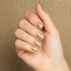 Mano con las uñas pintadas con esmalte tradicional Morgan Taylor Bronzed, color Amarillos acabado Glitter