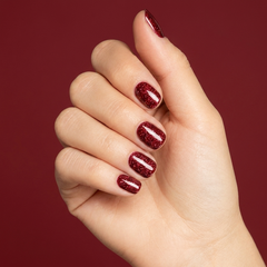 Mano con las uñas pintadas con esmalte tradicional Morgan Taylor Good Gossip, color Rojos acabado Shimmer