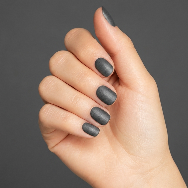 Mano con las uñas pintadas con esmalte tradicional Morgan Taylor Midnight Caller, color Negros acabado Shimmer