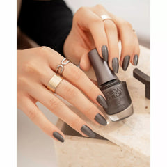 Mano sosteniendo el frasco de esmalte tradicional Morgan Taylor Midnight Caller