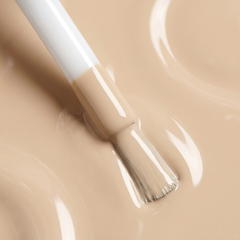 Primer plano del pincel con esmalte tradicional Morgan Taylor Need a Tan, color Nudes acabado Cream, textura del color
