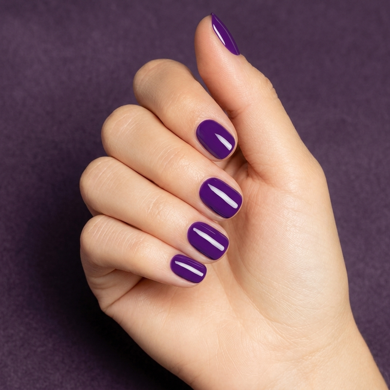 Mano con las uñas pintadas con esmalte tradicional Morgan Taylor You Glare I Glow, color Morados acabado Cream