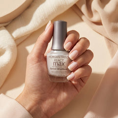 Mano sosteniendo Morgan Taylor Reactmax Optical Brightener Nail Strengthener + Extended Wear Base Coat