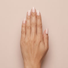 Mano con las uñas pintadas con esmalte tradicional Morgan Taylor Simply Irresistible, color Nudes acabado Cream