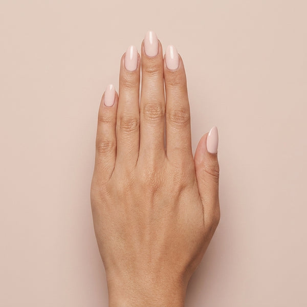 Mano con las uñas pintadas con esmalte tradicional Morgan Taylor Simply Irresistible, color Nudes acabado Cream
