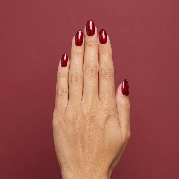 Mano con las uñas pintadas con esmalte tradicional Morgan Taylor Best Dressed, color Rojos acabado Shimmer