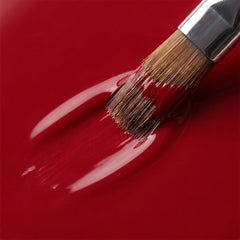 Primer plano del pincel con esmalte tradicional Morgan Taylor Best Dressed, color Rojos acabado Shimmer, textura del color