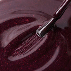 Primer plano del pincel con esmalte tradicional Morgan Taylor Seal The Deal, color Morados acabado Glitter, textura del color