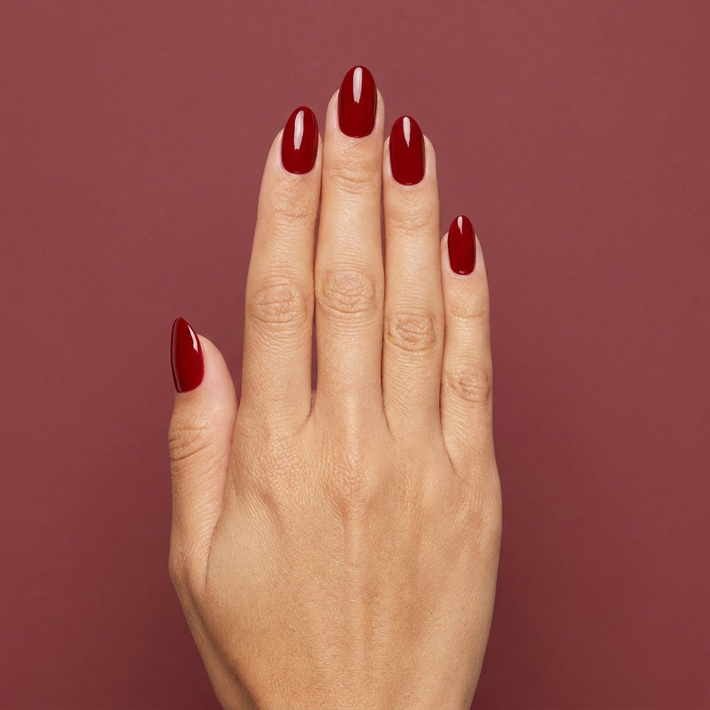 Mano con las uñas pintadas con esmalte tradicional Morgan Taylor Scandalous, color Rojos acabado Cream