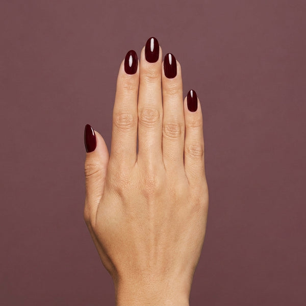 Mano con las uñas pintadas con esmalte tradicional Morgan Taylor A Touch Of Sass, color Borgoñas acabado Cream