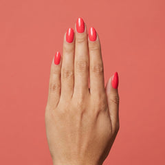 Mano con las uñas pintadas con esmalte tradicional Morgan Taylor Hip Hot Coral, color Rojos acabado Cream