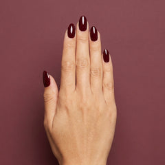 Mano con las uñas pintadas con esmalte tradicional Morgan Taylor Looking For a Wingman, color Borgoñas acabado Cream