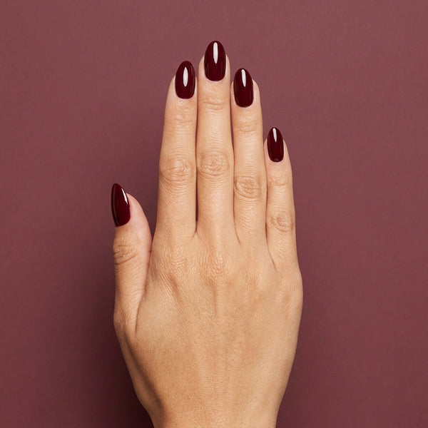Mano con las uñas pintadas con esmalte tradicional Morgan Taylor Looking For a Wingman, color Borgoñas acabado Cream
