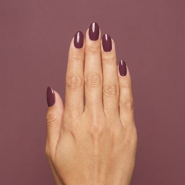 Mano con las uñas pintadas con esmalte tradicional Morgan Taylor Figure 8s & Heartbreaks, color Borgoñas acabado Cream