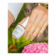 Mano con uñas nude rosado con glitter sosteniendo el frasco blanco Gelish Flash Glam Bright Up My Alley con tapa FLASH TO ACTIVATE