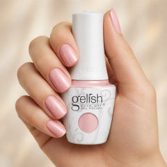 Mano sosteniendo el frasco de esmalte en gel Gelish Follow The Petals, color Rosas acabado Shimmer, con las uñas pintadas del mismo tono
