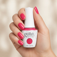 Mano sosteniendo el frasco de esmalte en gel Gelish Passion, color Rosas acabado Cream, con las uñas pintadas del mismo tono