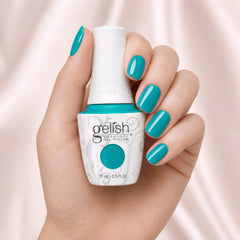 Mano sosteniendo el frasco de esmalte en gel Gelish Radiance Is My Middle Name, color Verdes acabado Cream, con las uñas pintadas del mismo tono