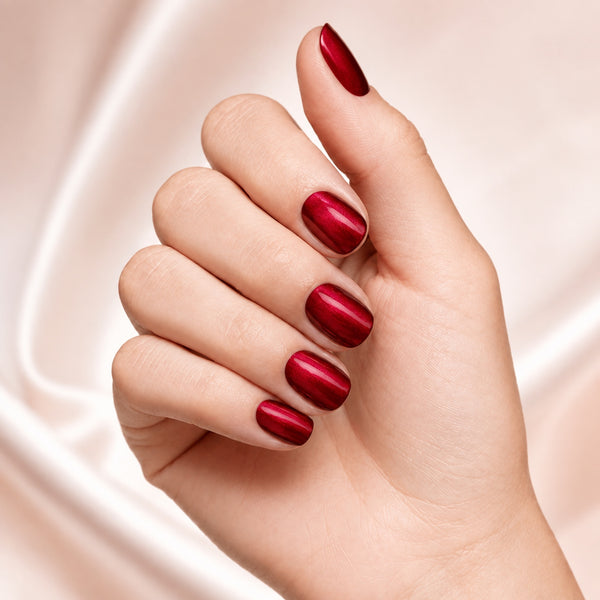 Esmalte tradicional Morgan Taylor What's Your Poinsettia?, color Rojos acabado Shimmer en uso durante la aplicación